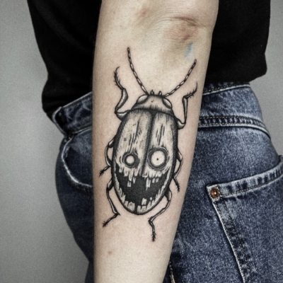 Creepy smilling bug in a tattoo form for a happy client.