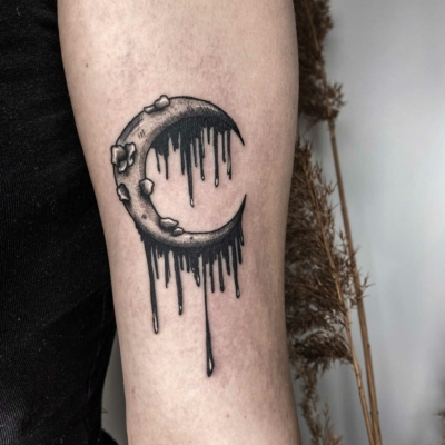 Creepy moon tattoo on arm