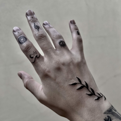 Hand delicate tattoo full of symbols and natural themes.