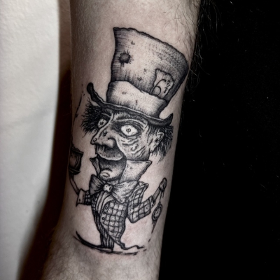 Mad Hatter arm tattoo in a dark, creepy macabre style