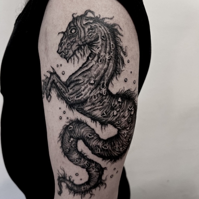 Kelpie arm tattoo in a dark moody style