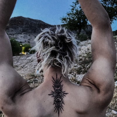Three eye tattoo on a man with a mountain Granada (Spain) background